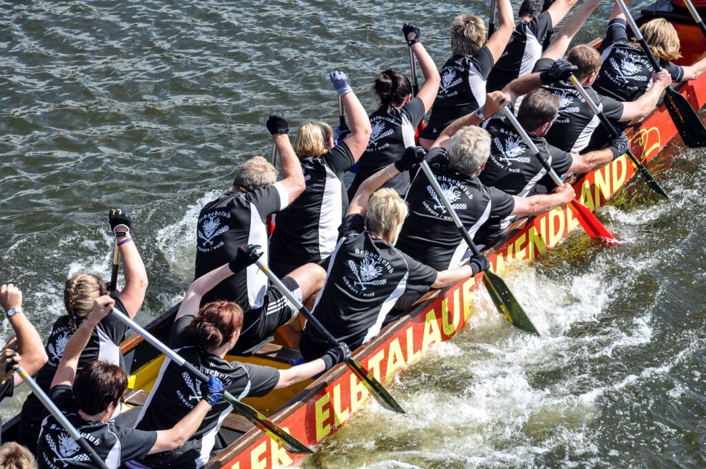 A dynamic dragon boat team races on a river in Hamburg, showcasing teamwork and sportsmanship.